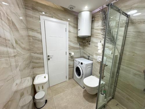 a bathroom with a toilet and a washing machine at Apartmani Avanti Becici in Becici