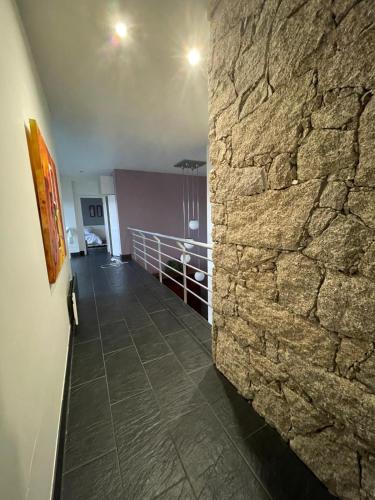 a room with a stone wall and a hallway at Escusa in Baião