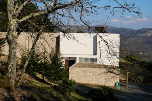 a white building on top of a hill at Escusa in Baião