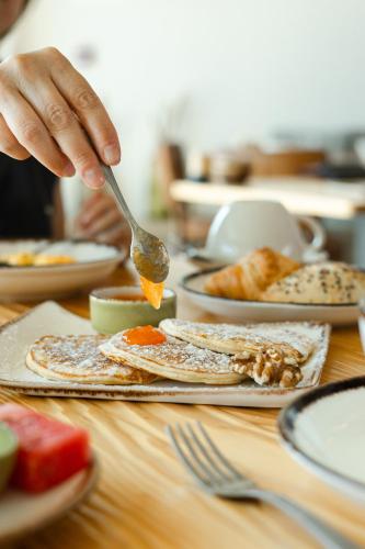 a person is eating food on a table at Sleep & Nature Hotel in Lavre