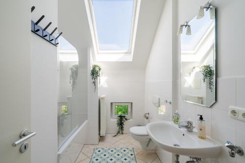 a bathroom with a sink and a toilet and a window at Sky Loft Leipzig - moderne Dachwohnung mit Terrasse und Blick aufs Rathaus in Leipzig