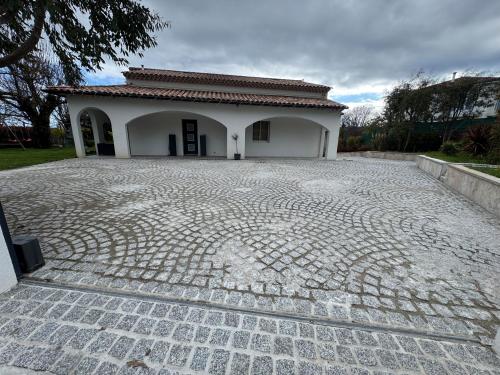 a building with a cobblestone driveway in front of it at Villa Élégante à Berre-les-Alpes - Terrasse, Piscine & Vue Panoramique in Berre-les Alpes