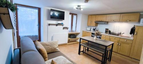 un salon avec un canapé et une table dans une cuisine dans l'établissement Le Cocon d'Estoublon, à Estoublon