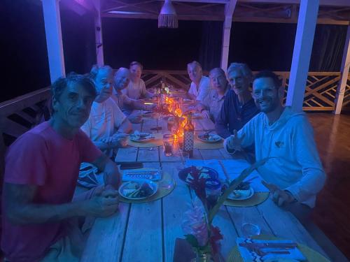 a group of people sitting around a wooden table at SEAHORSE POINT HOTEL and NATURE RESERVE in Bocas del Toro
