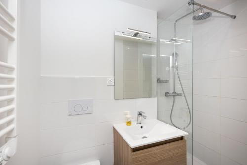 une salle de bain blanche avec un lavabo et une douche dans l'établissement L'Auberlac'h, à Brest