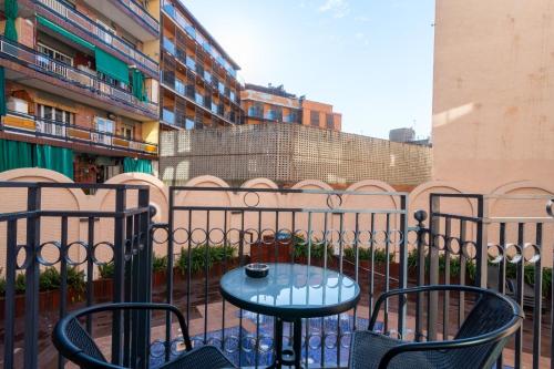 a table and chairs on a balcony with a fence at Nicolle Apartment Lloret de Mar in Lloret de Mar