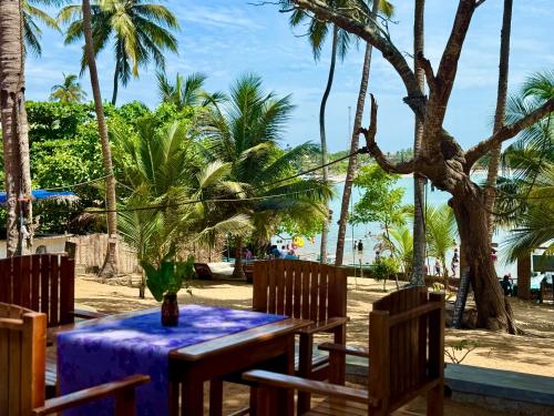 a table with a purple table cloth on a beach at Kudah Bay Surf Camp in Arugam Bay
