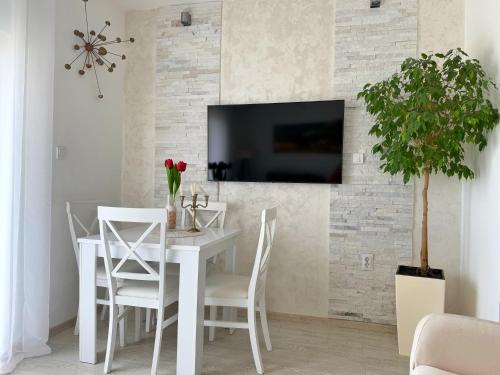 a dining room with a white table and chairs at Apartmani Avanti Becici in Becici