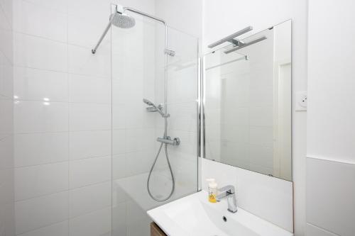 une salle de bain blanche avec une douche et un lavabo dans l'établissement Le Dellec, à Brest