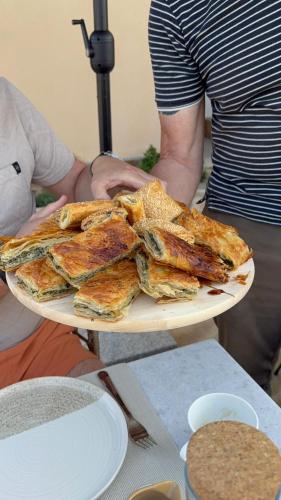 a man holding a plate of food on a table at Boutique Hotel Caramel in Syvota