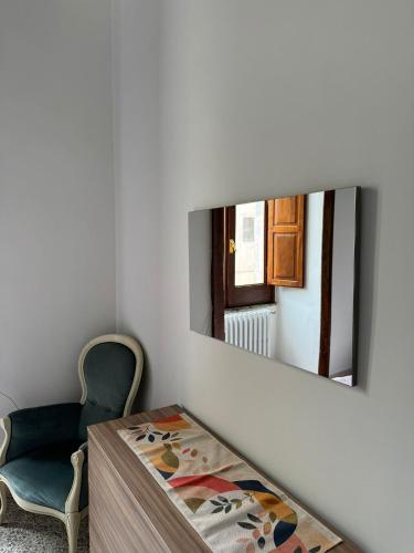 a mirror on a wall with a table and a chair at Cuore Urbano in Pietramelara
