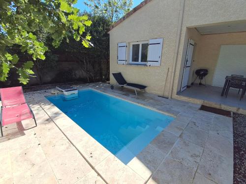 - une piscine avec une chaise à côté d'une maison dans l'établissement Gîte avec piscine privé, à Vogüé