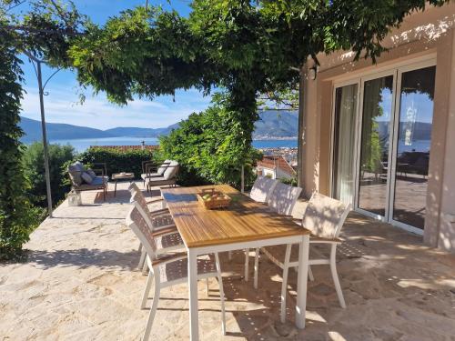 a wooden table and chairs on a patio at Villa Antonia in Tivat