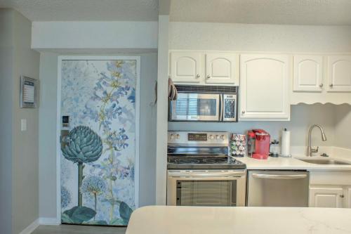 a kitchen with white cabinets and a stove top oven at Inviting Virginia Beach Condo with Community Pool in Virginia Beach