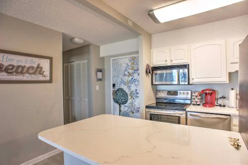 a kitchen with white cabinets and a counter top at Inviting Virginia Beach Condo with Community Pool in Virginia Beach