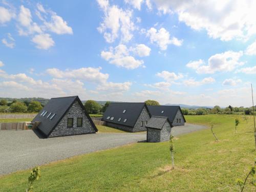 a group of houses in a field with a road at Hill Radnor - The Sheepfold in Llandrindod Wells
