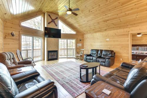 a living room with leather furniture in a log cabin at Waterfront Davis Pond Cabin with Dock and Kayaks! in Holden