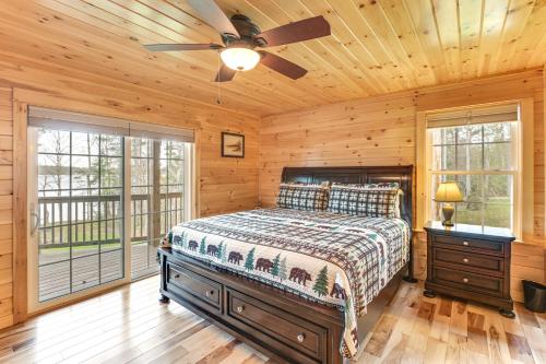 a bedroom with a bed and a ceiling fan at Waterfront Davis Pond Cabin with Dock and Kayaks! in Holden