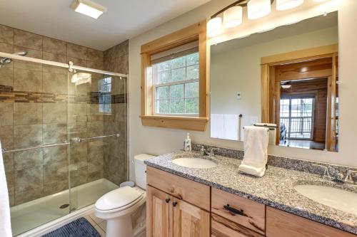 a bathroom with two sinks and a shower and a toilet at Waterfront Davis Pond Cabin with Dock and Kayaks! in Holden
