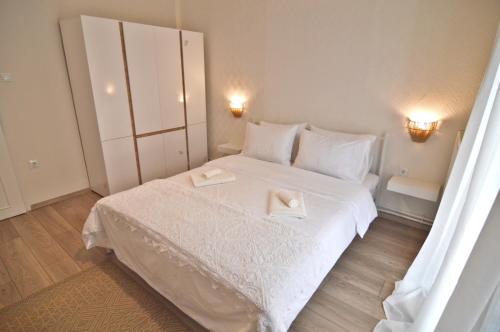 a bedroom with a white bed with two towels on it at Camelia Luxury Apt in Kastoria