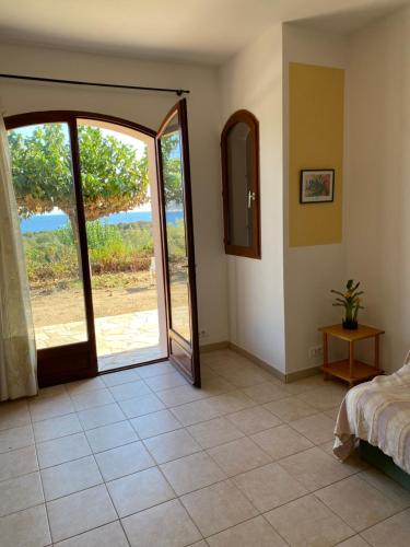 a bedroom with a large sliding glass door with a view at GRANDE VILLA TIZZANO A 200 M DE LA PLAGE 18 PERS in Sartène