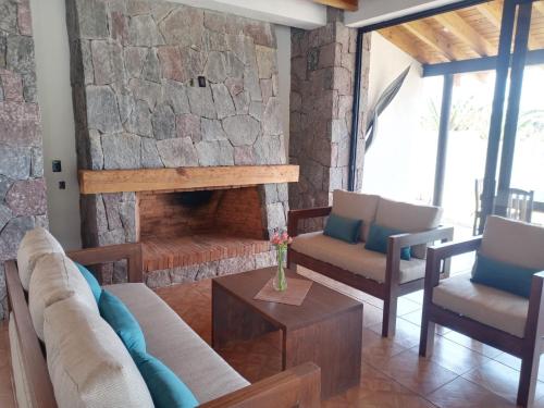 a living room with a stone fireplace with couches and chairs at Hotel Campestre, Valle de Bravo in Valle de Bravo