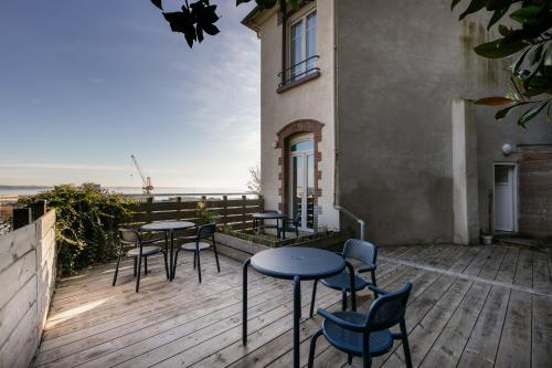 un patio avec tables et chaises sur un balcon dans l'établissement Le Roz, à Brest