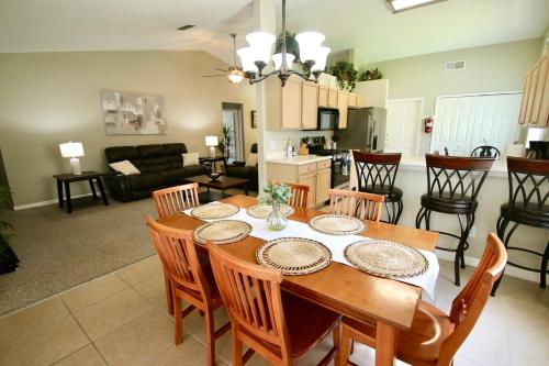 a dining room and living room with a table and chairs at Family Escape Close to parks in Orlando