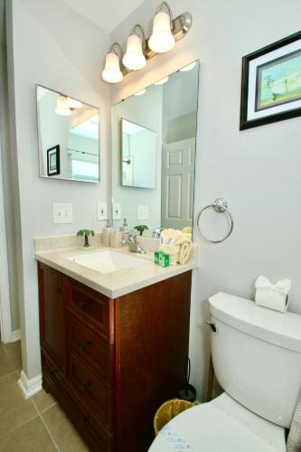 a bathroom with a sink and a toilet and a mirror at Family Escape Close to parks in Orlando