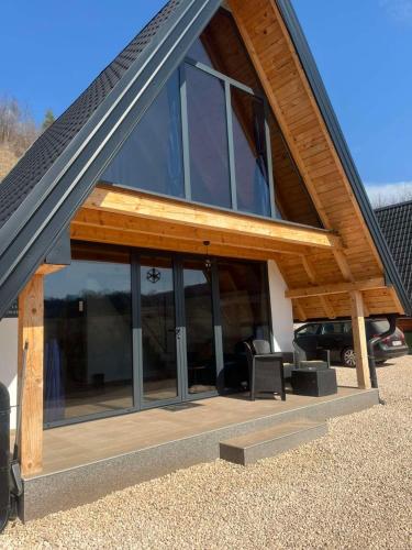a house with glass windows and a roof at Bungalov La Repit in Šipovo