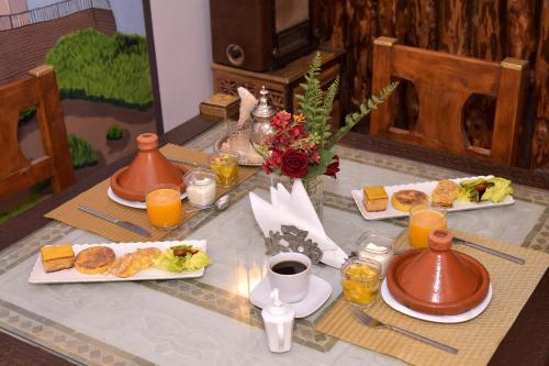 a table topped with plates of food and orange juice at RIAD KALE POLIS in Marrakech