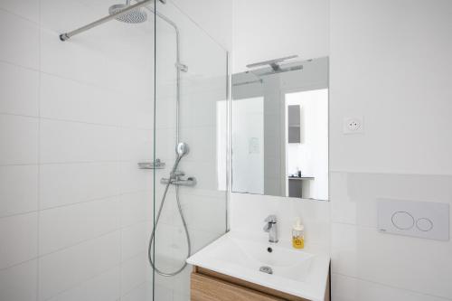 une salle de bain blanche avec une douche et un lavabo dans l'établissement Le Moulin Blan, à Brest