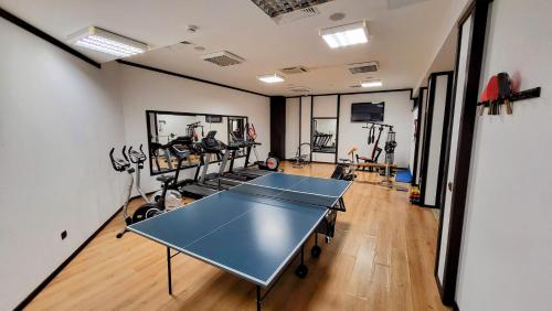 a gym with a ping pong table in a room at Panorama Family Hotel in Zlatograd