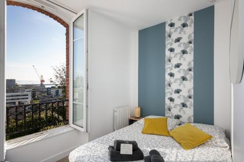 une chambre avec un lit et une grande fenêtre dans l'établissement Le Moulin Blan, à Brest