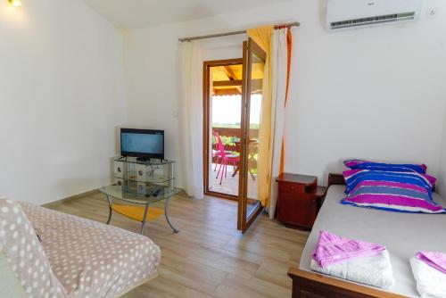 a bedroom with a bed and a television and a table at Apartmani Popović in Popovići