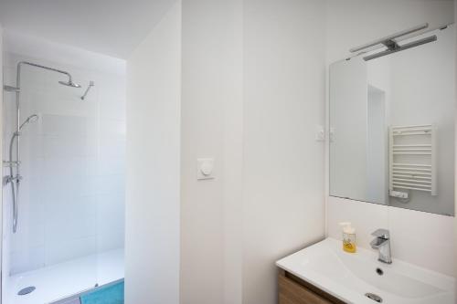 une salle de bain blanche avec un lavabo et une douche dans l'établissement Sainte Anne du Porzic, à Brest