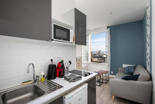 une cuisine avec un évier et un canapé dans une chambre dans l'établissement Sainte Anne du Porzic, à Brest