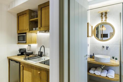 a kitchen with wooden cabinets and a sink and a mirror at Skopelos Prime Central Stays in Skopelos Town