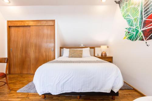 a bedroom with a bed and a wooden door at The Gallery in Mexico City