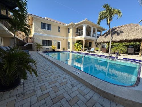 a swimming pool in front of a house at Beach Aqualina Apartments in Fort Lauderdale