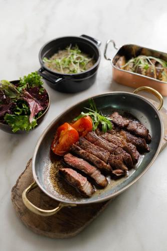 a plate of meat and vegetables on a table at Sleep & Nature Hotel in Lavre