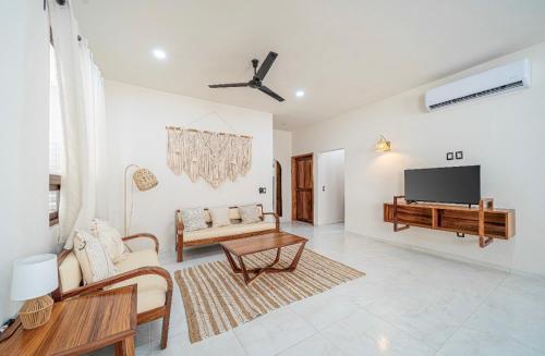 a living room with a couch and a tv at Departamentos Ámbar in Santa Cruz Huatulco