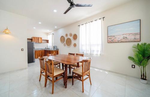 a kitchen and dining room with a wooden table and chairs at Departamentos Ámbar in Santa Cruz Huatulco