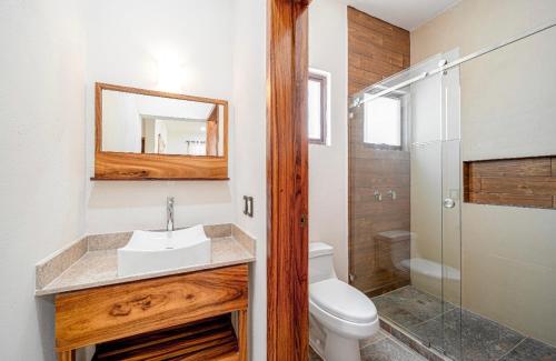 a bathroom with a toilet and a sink and a shower at Departamentos Ámbar in Santa Cruz Huatulco