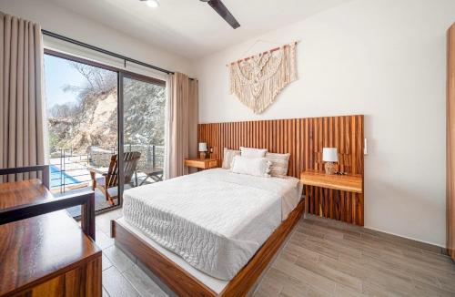 a bedroom with a bed and a large window at Departamentos Ámbar in Santa Cruz Huatulco