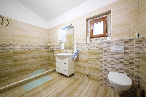 un baño con inodoro y lavabo en Apartmani Popović, en Popovići