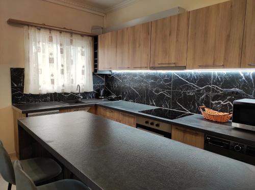 a kitchen with a black counter top and wooden cabinets at Juliette Apartments in Faraklata