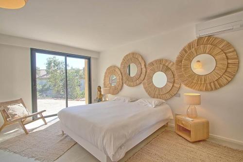 une chambre avec un lit et des miroirs au mur dans l'établissement Villa vue mer, piscine, plage à pieds, à Hyères