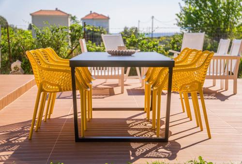 a table and four chairs with a laptop on it at Vitta's House in Kanali