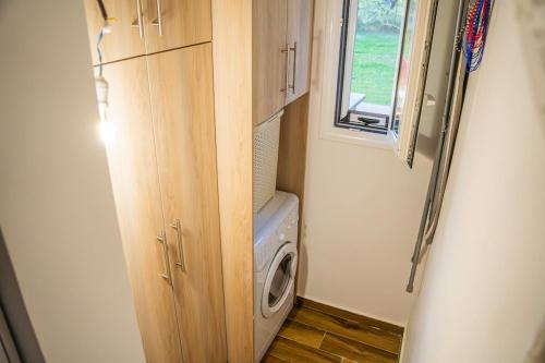 a small room with a washing machine and a window at Vitta's House in Kanali